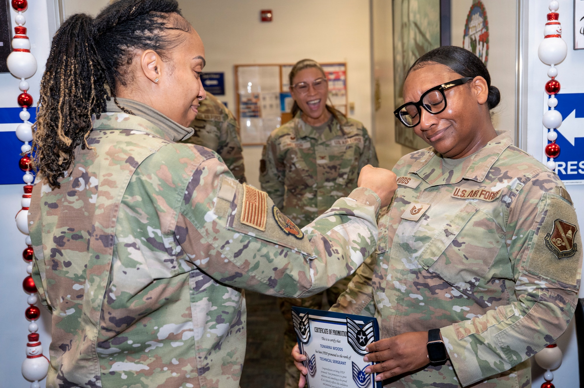 U.S. Air Force Senior Master Sgt. Rochell Brown, left, flight chief of the 11th Military Personnel Flight, pins the rank of technical sergeant on Tech. Sgt. Tomarra Woods, right, the noncommissioned officer in charge of outbound assignments with the 11th MPF, during Woods’ promotion ceremony on Joint Base Anacostia-Bolling, Washington, D.C., Nov. 25, 2025. Woods received the Stripes for Exceptional Performers promotion for demonstrating excellence and exceeding Air Force standards. (U.S. Air Force photo by Hayden Hallman)