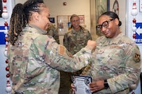 U.S. Air Force Senior Master Sgt. Rochell Brown, left, flight chief of the 11th Military Personnel Flight, pins the rank of technical sergeant on Tech. Sgt. Tomarra Woods, right, the noncommissioned officer in charge of outbound assignments with the 11th MPF, during Woods’ promotion ceremony on Joint Base Anacostia-Bolling, Washington, D.C., Nov. 25, 2025. Woods received the Stripes for Exceptional Performers promotion for demonstrating excellence and exceeding Air Force standards. (U.S. Air Force photo by Hayden Hallman)