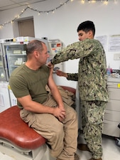 251204-N-FT324-9120. ROTA, Spain (Dec. 4, 2025) — Hospital Corpsman Second Class Christian Herrera, a corpsman assigned to Navy Medicine Readiness and Training Command (NMRTC) Rota, vaccinates a member of Marine Medium Tiltrotor Squadron 162 during the command’s annual influenza vaccination campaign, supporting Force Health Protection and operational readiness across the joint force. (U.S. Navy Photo by Lt. Cmdr. Alicia Sacks)