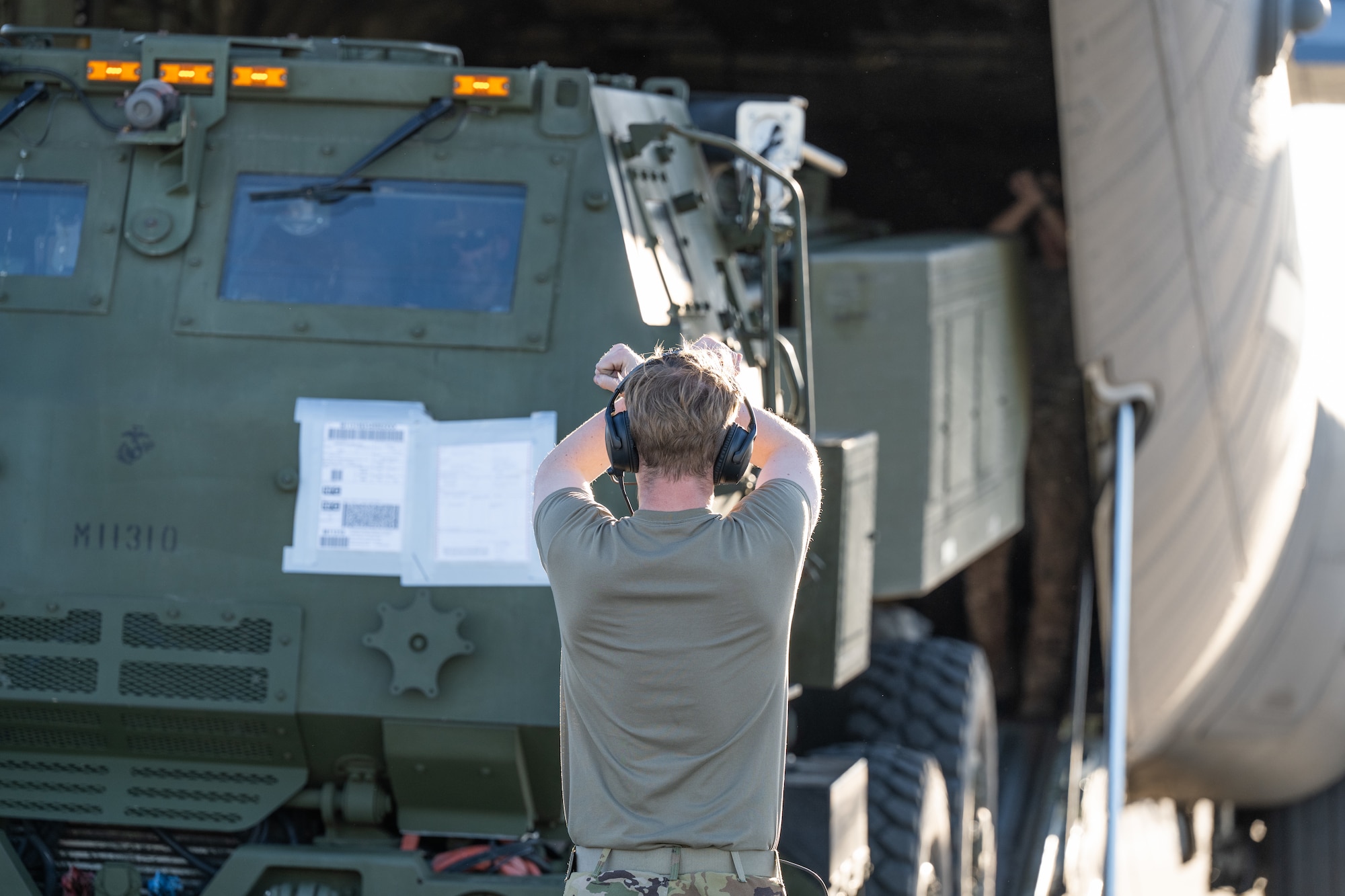 Airmen stand in the back of a C-130J