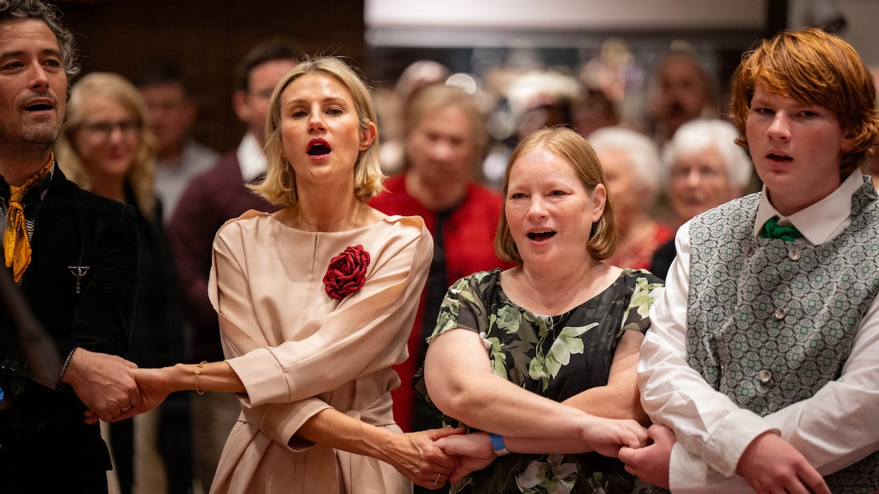 Latvian-Americans join arms while singing