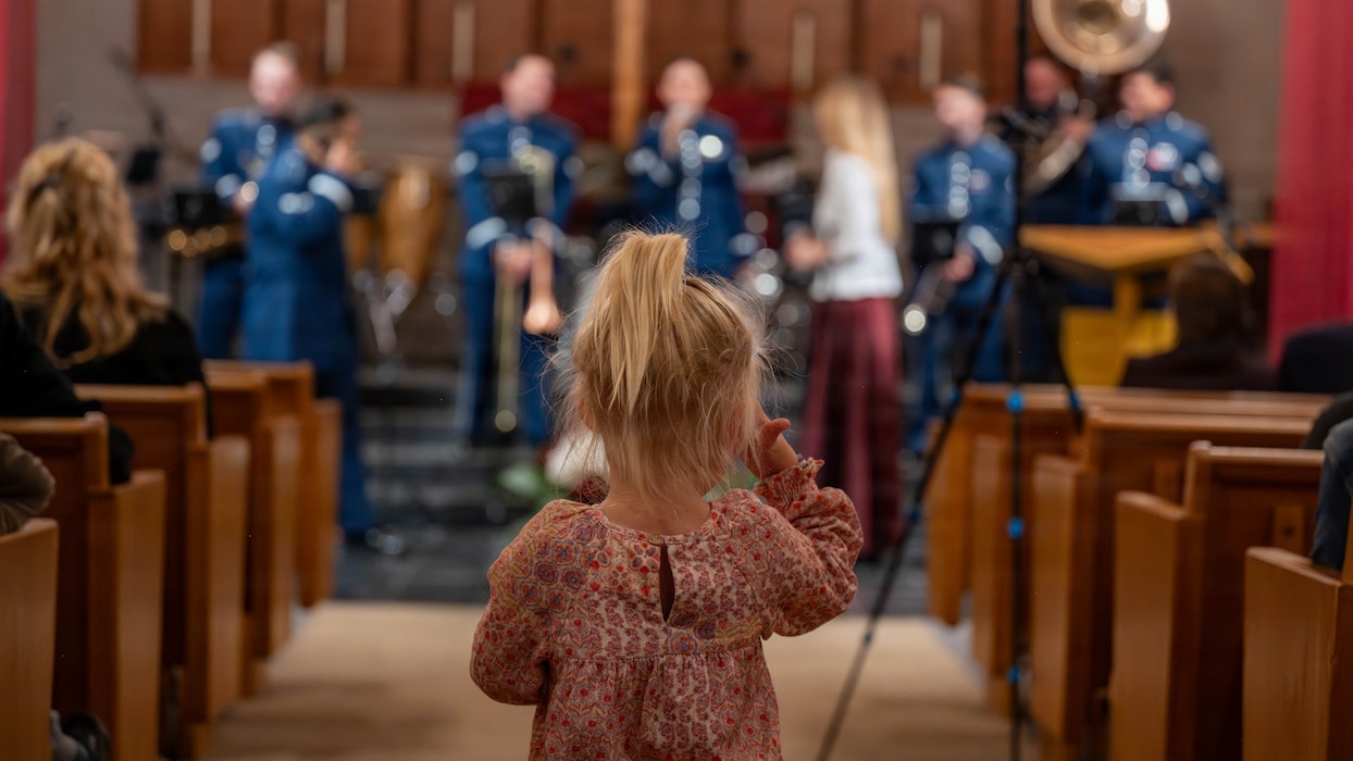 A child with back to camera watches the band