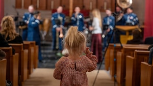 A child with back to camera watches the band