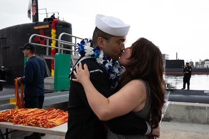 NAVAL BASE POINT LOMA, Calif. (Sept. 29, 2025) A Sailor assigned to Los Angeles-class fast-attack submarine USS Santa Fe (SSN 763) has his first kiss after returning to Naval Base Point Loma following a six-month deployment to the U.S. Indo-Pacific Command area of responsibility, Sept. 29, 2025. Santa Fe is assigned to Commander, Submarine Squadron 11, home to four Los Angeles-class fast-attack submarines, which are capable of supporting various missions, including anti-submarine warfare, anti-ship warfare, strike warfare and intelligence, surveillance and reconnaissance. (U.S. Navy photo by Mass Communication Specialist 2nd Class Rashan Jefferson)