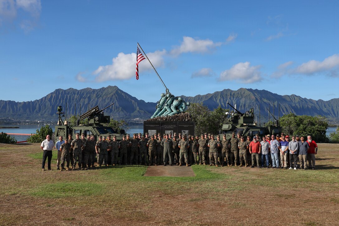 U.S. Marines with 1st Low Altitude Air Defense Battalion (LAAD), Marine Air Control Group 18, 1st Marine Aircraft Wing, and civilian contractors pose for a photo at Marine Corps Base Hawaii, Dec. 12, 2025.