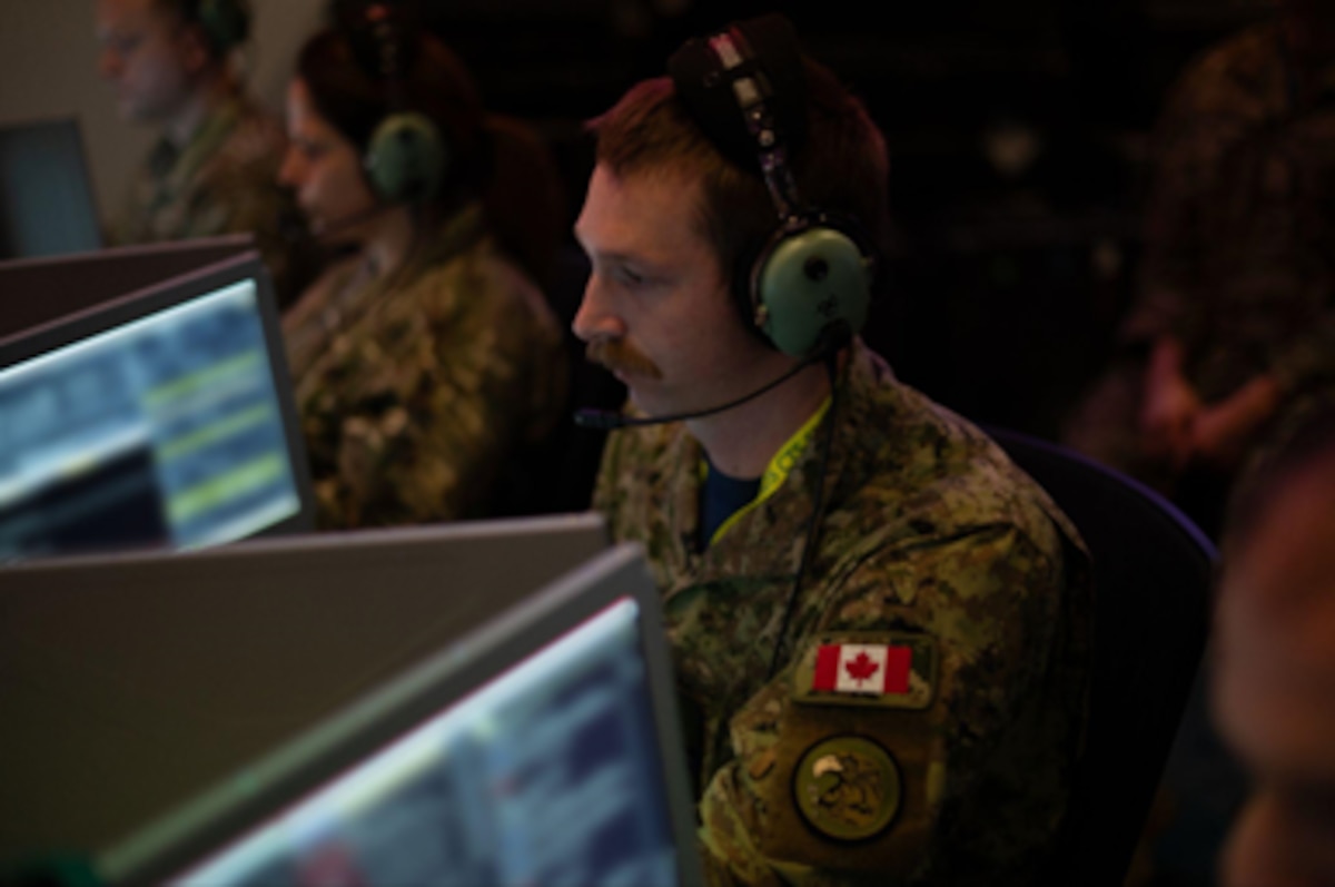 photo of RCAF and USAF warfighters wearing headsets while working on computers