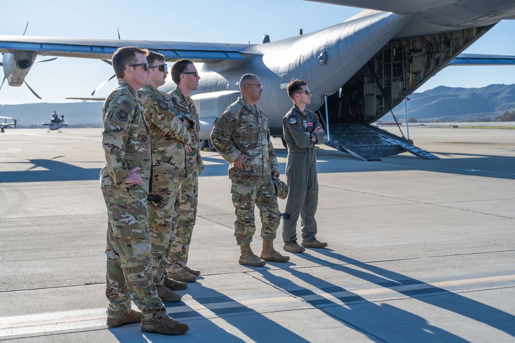 Airmen stand in the back of a C-130J