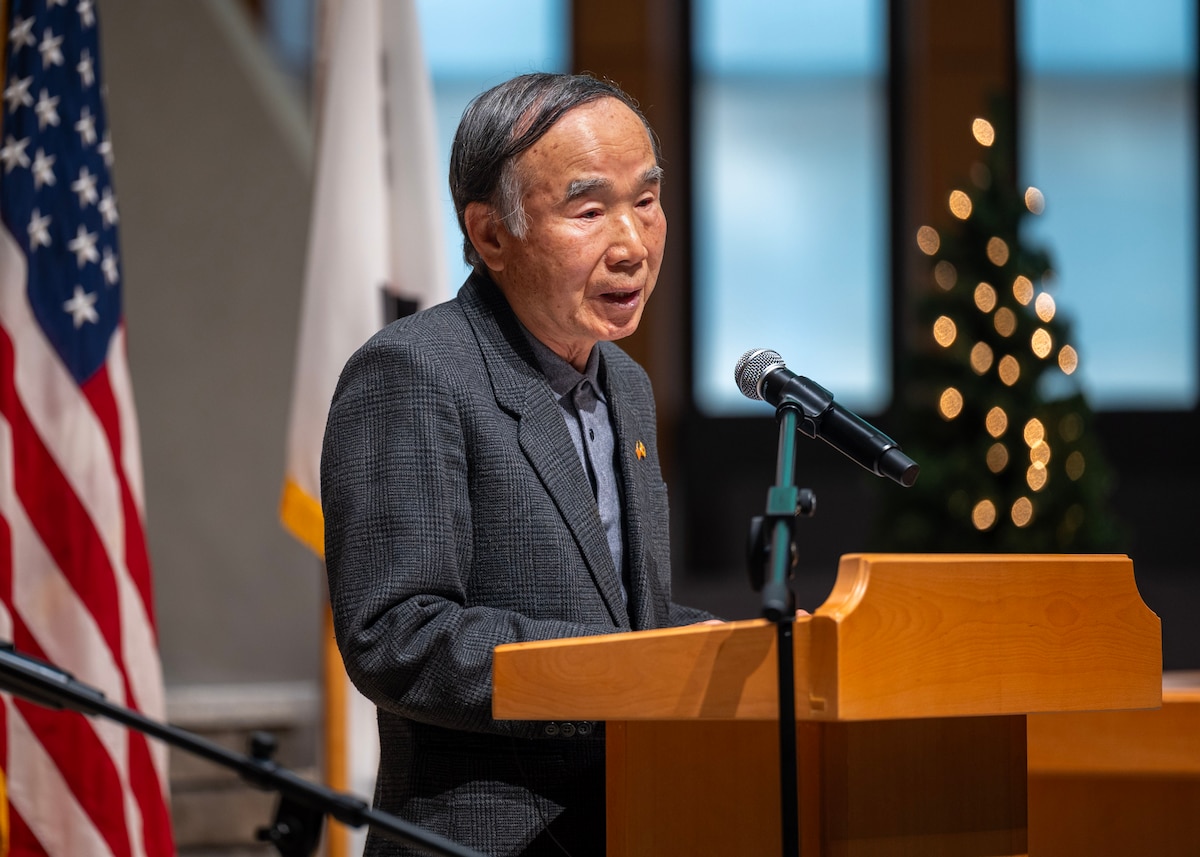Pak Ki-Un, Operation Kiddy Car ceremony guest speaker, shares his personal experiences during the Korean War at Osan Air Base, Republic of Korea, Dec. 17, 2025. Pak shared his personal experiences as an 8-year-old boy at the onset of the Korean War, offering firsthand insight into the fear, hardship and uncertainty faced during the conflict. (U.S. Air Force photo by Staff Sgt. Sarah Williams)