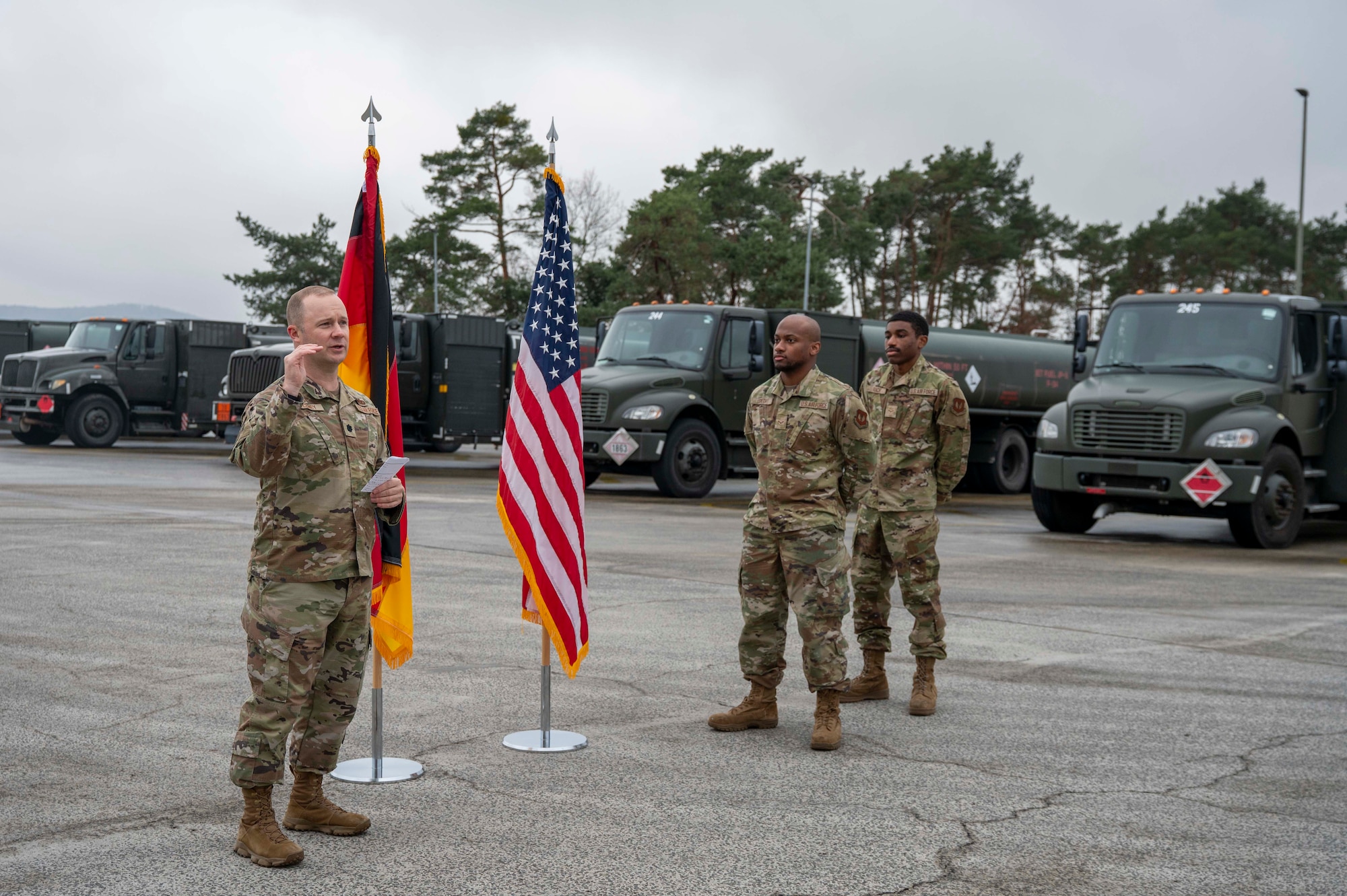 U.S. Air Force Lt. Col. Austin Deeney, 86th Logistics Readiness Squadron commander, recognizes Airman 1st Class Tariq Smith and A1C Mario Roach, 86th LRS fuels distribution operators, during a Knighting Ceremony at Ramstein Air Base, Germany, Dec. 5, 2025.