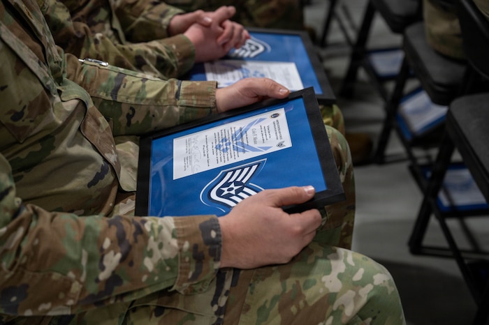 A person holds a framed certificate.