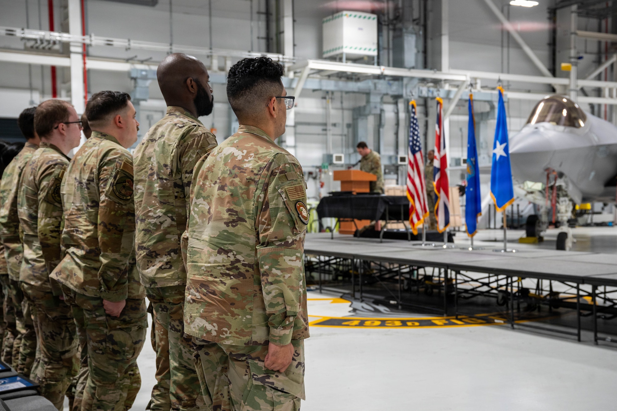 Military members stand for a ceremony.