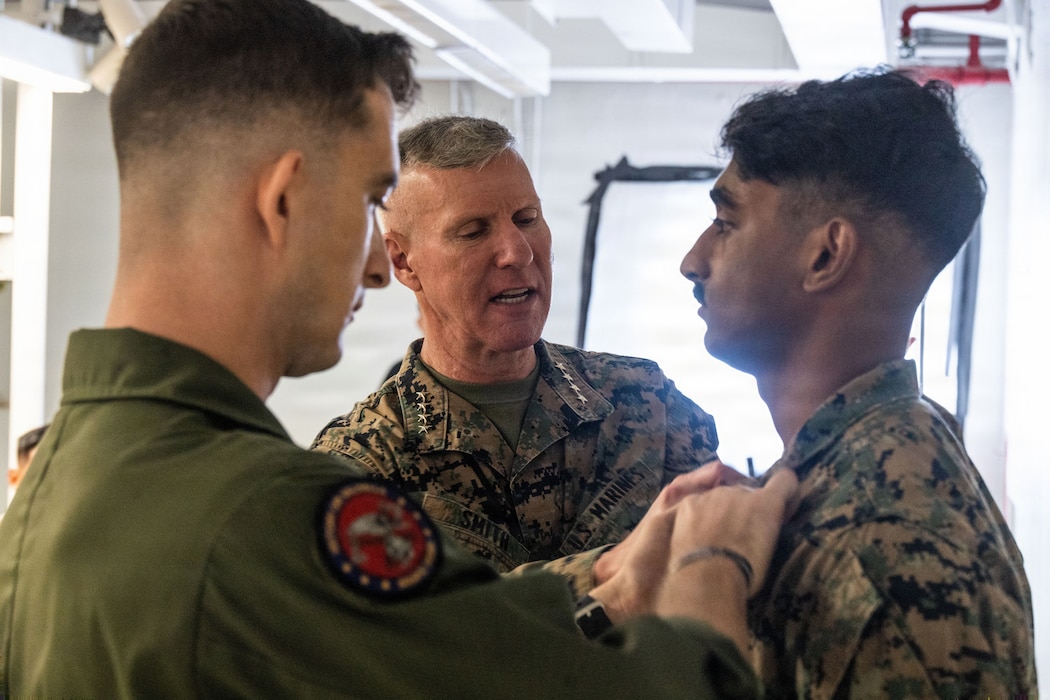 The 39th Commandant of the Marine Corps, Gen. Eric M. Smith, center, pins new chevrons on a a U.S. Marine with Marine Fighter Attack Squadron (VMFA) 225, U.S. Marine Corps Forces, South, after meritoriously promoting him to the rank of sergeant at Jose Aponte de la Torre Airport in Ceiba, Puerto Rico, Dec. 16, 2025. U.S. military forces are deployed to the Caribbean in support of the U.S. Southern Command mission, Department of War-directed operations, and the president’s priorities to disrupt illicit drug trafficking and protect the homeland. (U.S. Marine Corps photo)
