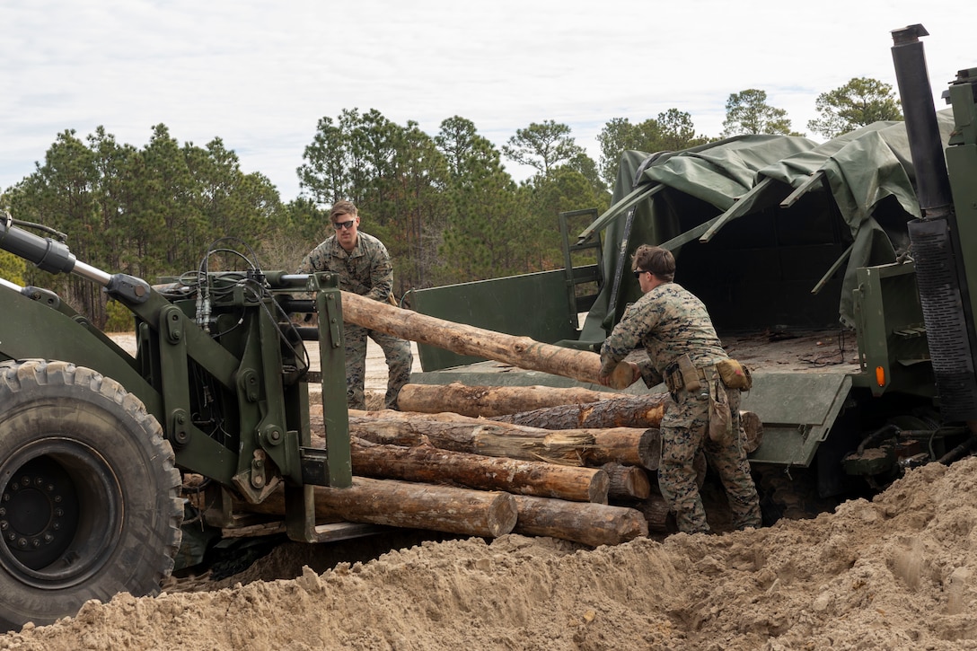 U.S. Marine Corps Cpl. Auston Pennell, left, and Cpl. Donovan Zamorski, motor transport vehicle operators with Combat Logistics Battalion 22, Combat Logistics Regiment 27, 2nd Marine Logistics Group, make a security point during a battalion field fortification exercise at Marine Corps Base Camp Lejeune, Dec. 12, 2025. CLB-22 held the battalion FEX to sustain training and readiness standards, increase technical proficiency, and enhance the battalion’s ability to complete core mission essential tasks. Pennell is a native of Ohio and Zamorski is a native of Illinois. (U.S. Marine Corps photo by Lance Cpl. Isabella Ramos)