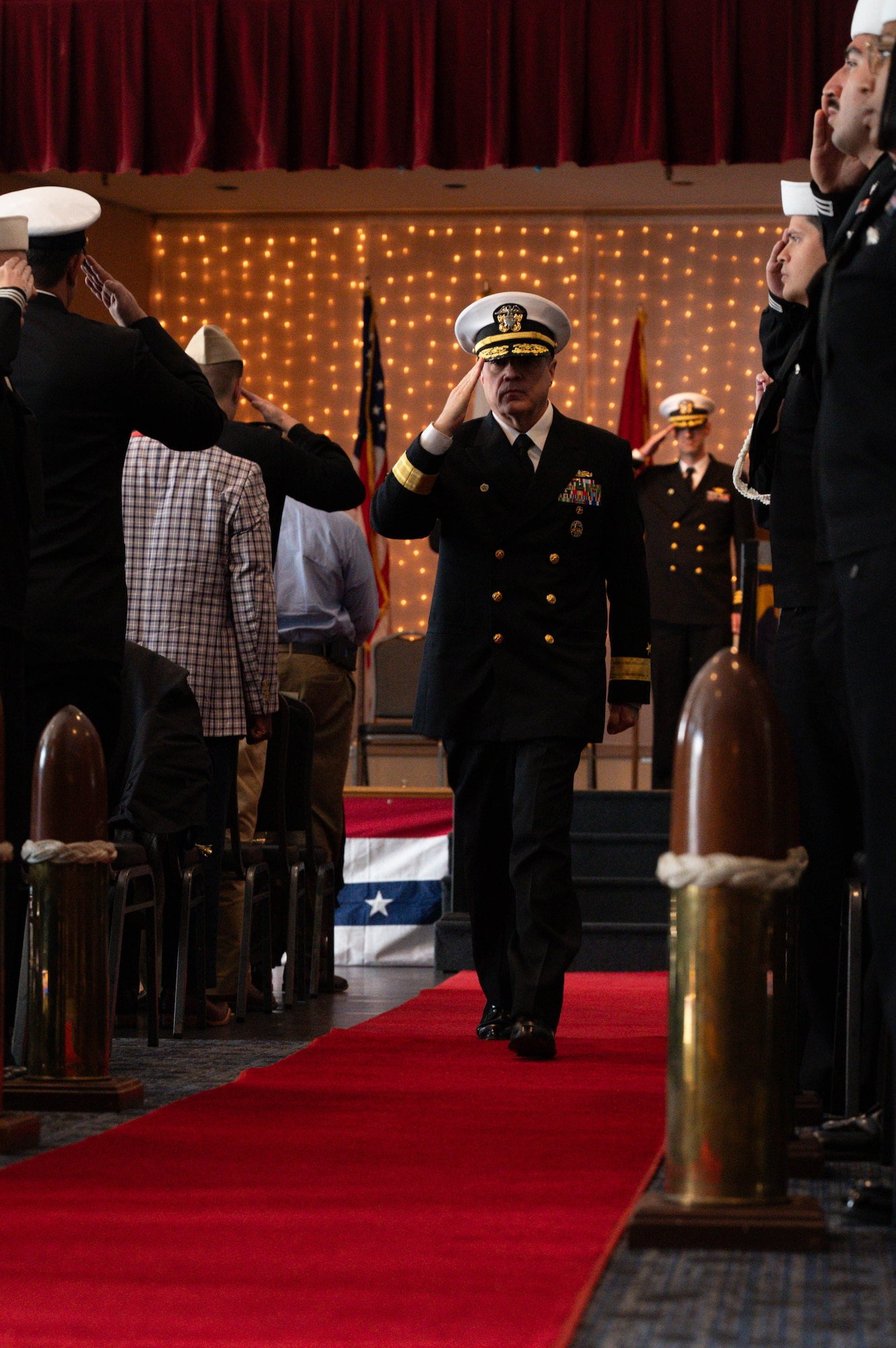 U.S. Navy Rear Admr. Kevin Kennedy, Deputy Chief of Naval Personnel Command and Commander Navy Personnel Command, gives a salute to the side boys during the departure of the official party at the NCBC change of command ceremony.