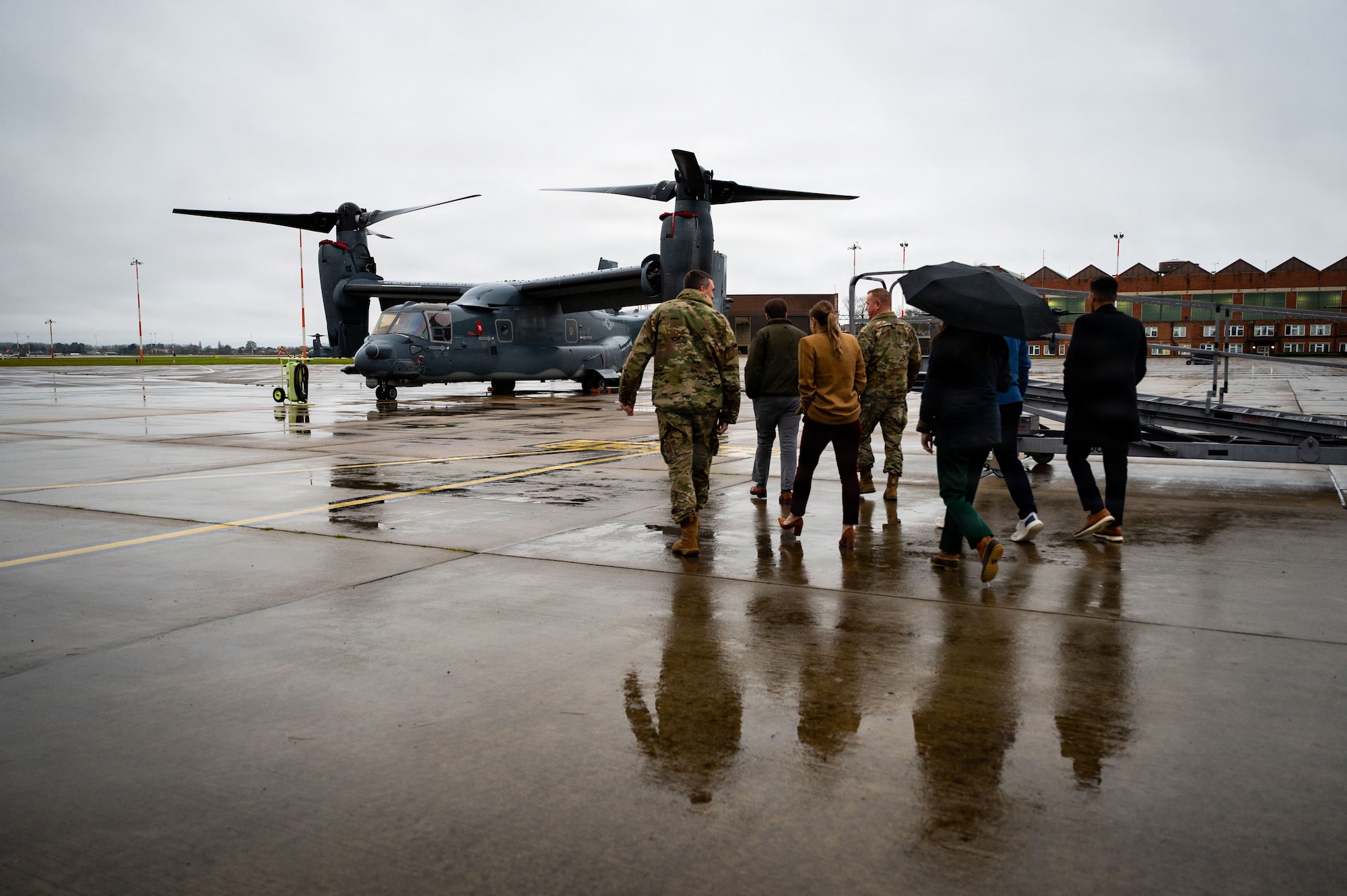 Professional staff members of the Senate Armed Services Committee walk towards a CV-22 Osprey assigned to the 352nd Special Operations Wing during a visit at RAF Mildenhall, England, Dec. 16, 2025.