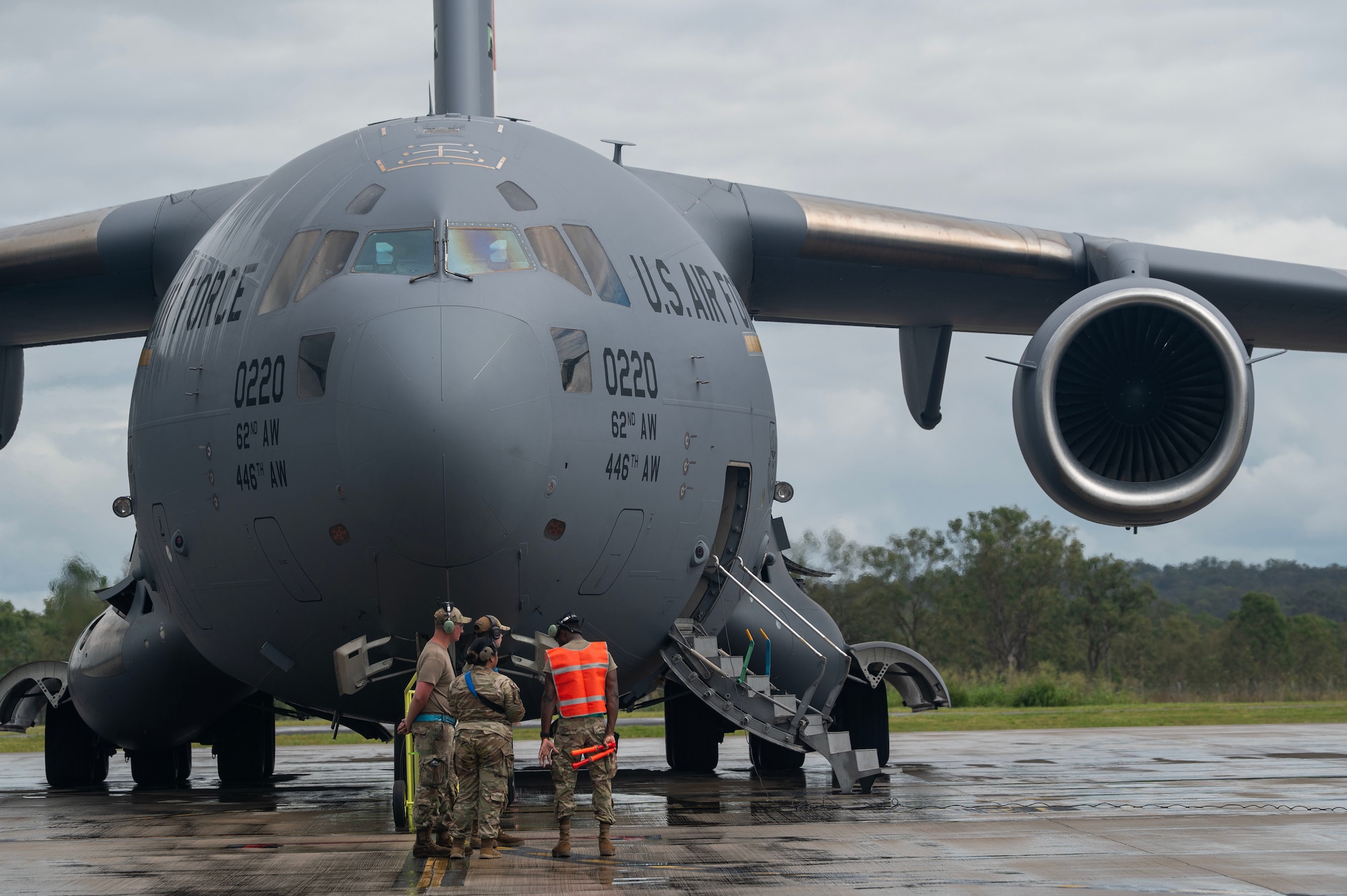 A group of airmen in uniform stand in front of a united states Air Force C-17