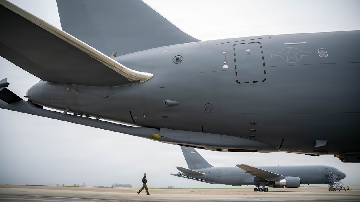 An Airman is visible, but small, with an aircraft in the foreground and background