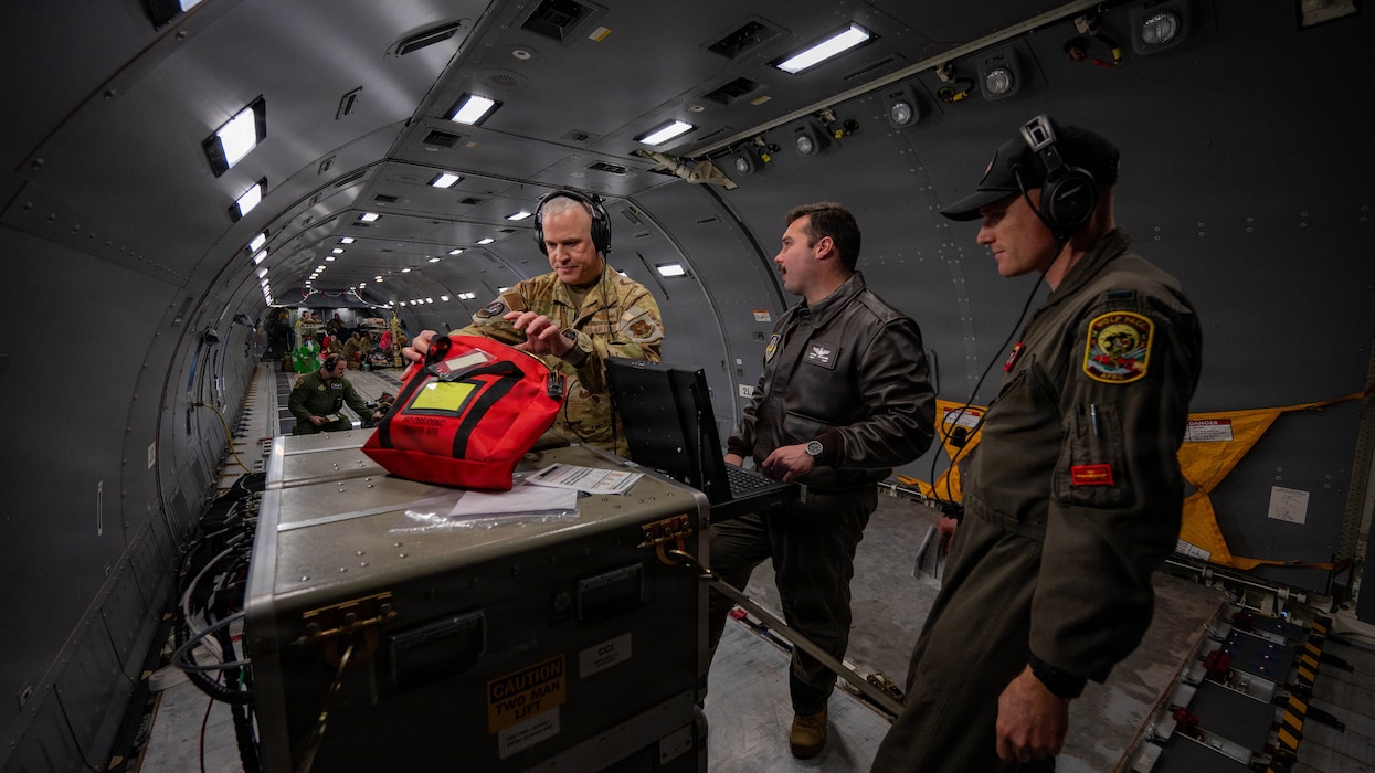 Airmen work aboard an aircraft in the cargo bay