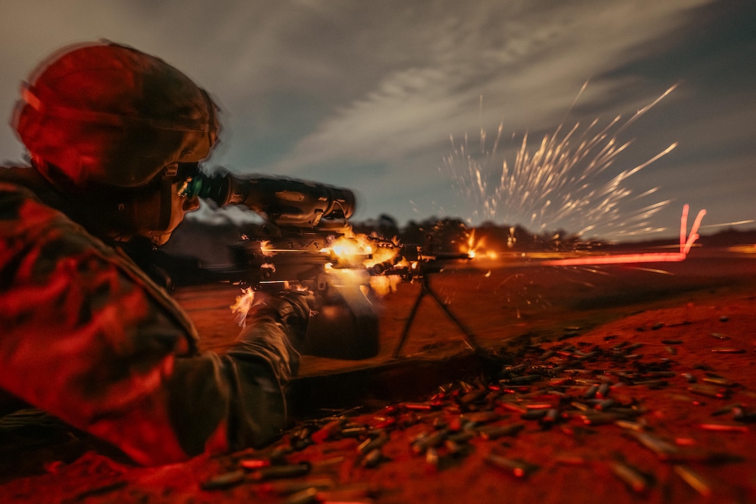 Sparks fly as a soldier lying on the ground fires a weapon, creating red lasers in the distance.