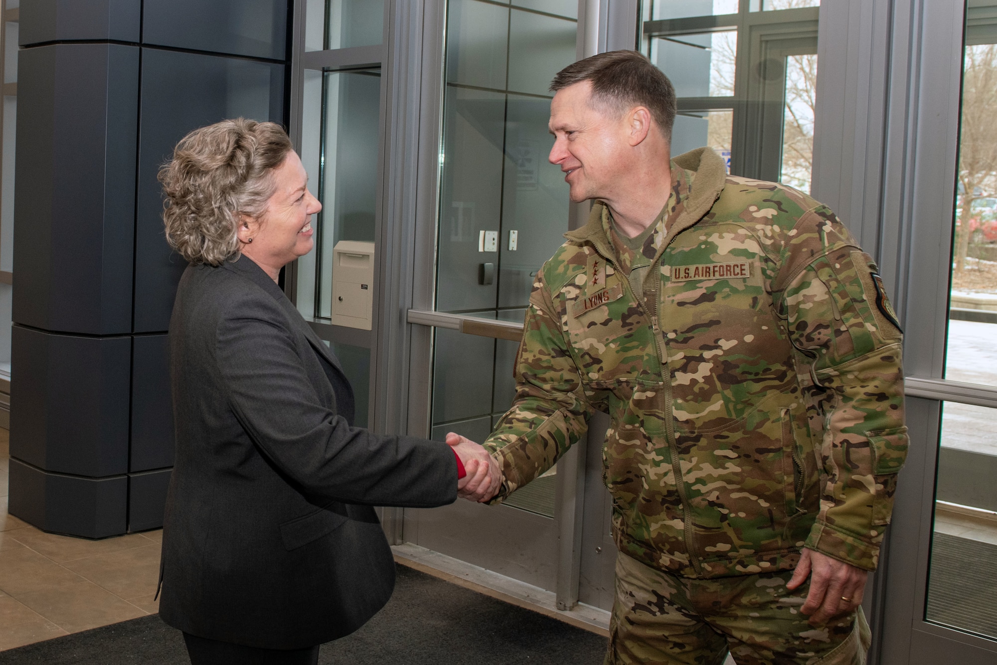 Brig. Gen. Amy Bumgarner, commander of the Air Force Office of Special Investigations, greets Lt. Gen. David B. Lyons, Inspector General of the Department of the Air Force, during his visit to AFOSI headquarters at the Russell-Knox Building in Quantico, Virginia, Dec. 15, 2025.