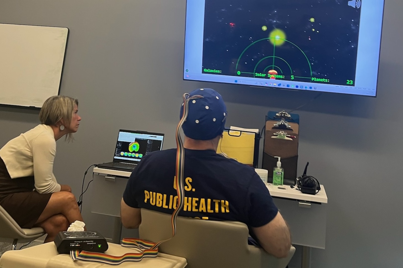 Public Health Service Lt. Austin D Hamilton, right, a licensed supervisory psychologist with the Fort Carson Intrepid Spirit Center, and Kirsten Larson, an ISC psychometrist, test out new neurofeedback equipment the ISC recently received. Neurofeedback is an evidenced-based practice that allows clinicians to “map” brain activity levels and compare the results to what is considered normal brain activity.