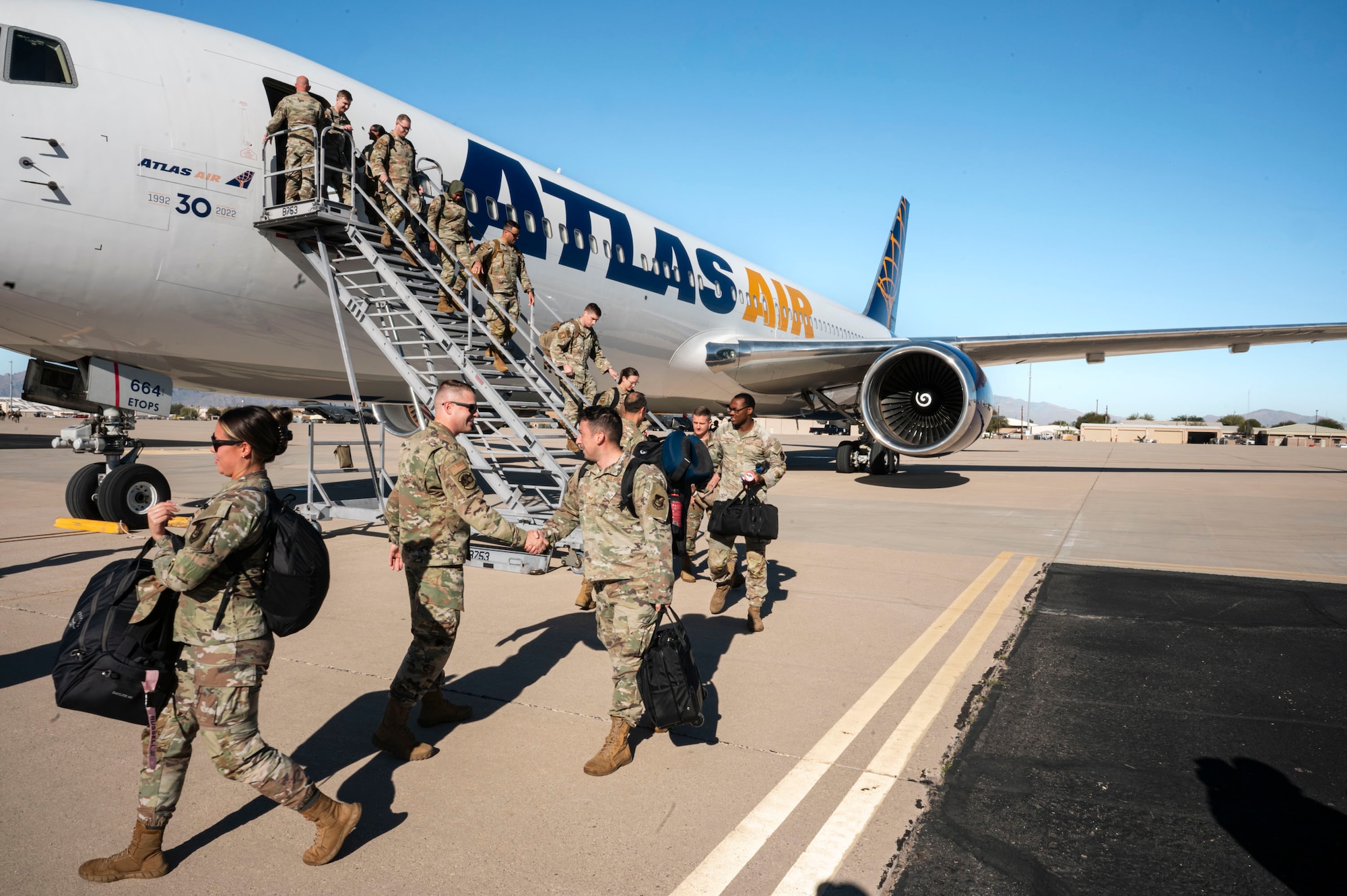 U.S. Air Force Airmen return from a deployment with the 11th Air Task Force at Davis-Monthan Air Force Base, Arizona, Dec. 17, 2025. Airmen were welcomed home by members of their command team while getting off the aircraft. (U.S. Air Force photo by Airman 1st Class Samantha Melecio)