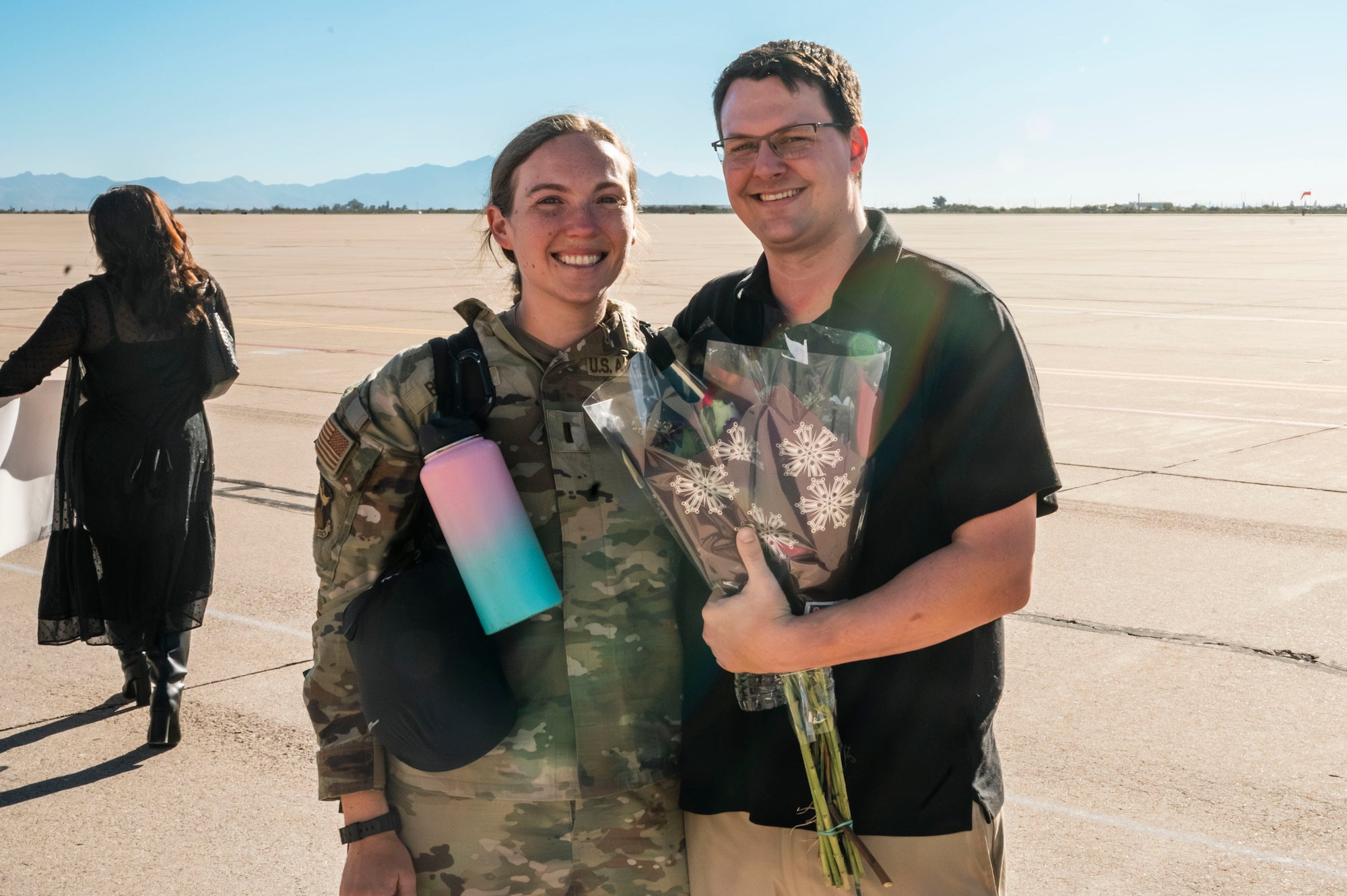 U.S. Air Force 2nd Lt. Grace Brandt, 355th Wing public affairs officer, poses for a photo with her spouse at Davis-Monthan Air Force Base, Arizona, Dec. 17, 2025. Brandt just returned from a 5-month deployment with the 11th Air Task Force. (U.S. Air Force photo by Airman 1st Class Samantha Melecio)