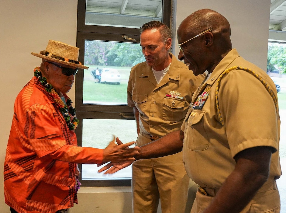 Rear Adm. Marc Williams, center, deputy commander, Navy Closure Task Force-Red Hill (NCTF-RH) and Capt. Gregory deWindt, chief of staff, NCTF-RH, greet Uncle Kalani Whitford, a community “Kupuna,” or elder, at the NCTF-RH open house held at the Oahu Veterans Center in Honolulu, Dec. 11, 2025. NCTF-RH hosted the quarterly open house for members of the community to learn about current and future efforts in support of the Red Hill Bulk Fuel Storage Facility (RHBFSF) decommissioning and the Navy’s ongoing environmental efforts. NCTF-RH was established by the Department of the Navy to safely decommission the RHBFSF and emphasize the Navy's commitment to the community and the environment. NCTF-RH continues to engage with the people of Hawaii, regulatory agencies, and other stakeholders as it safely and deliberately decommissions the facility. (U.S. Navy photo by Mass Communication Specialist 1st Class Glenn Slaughter)