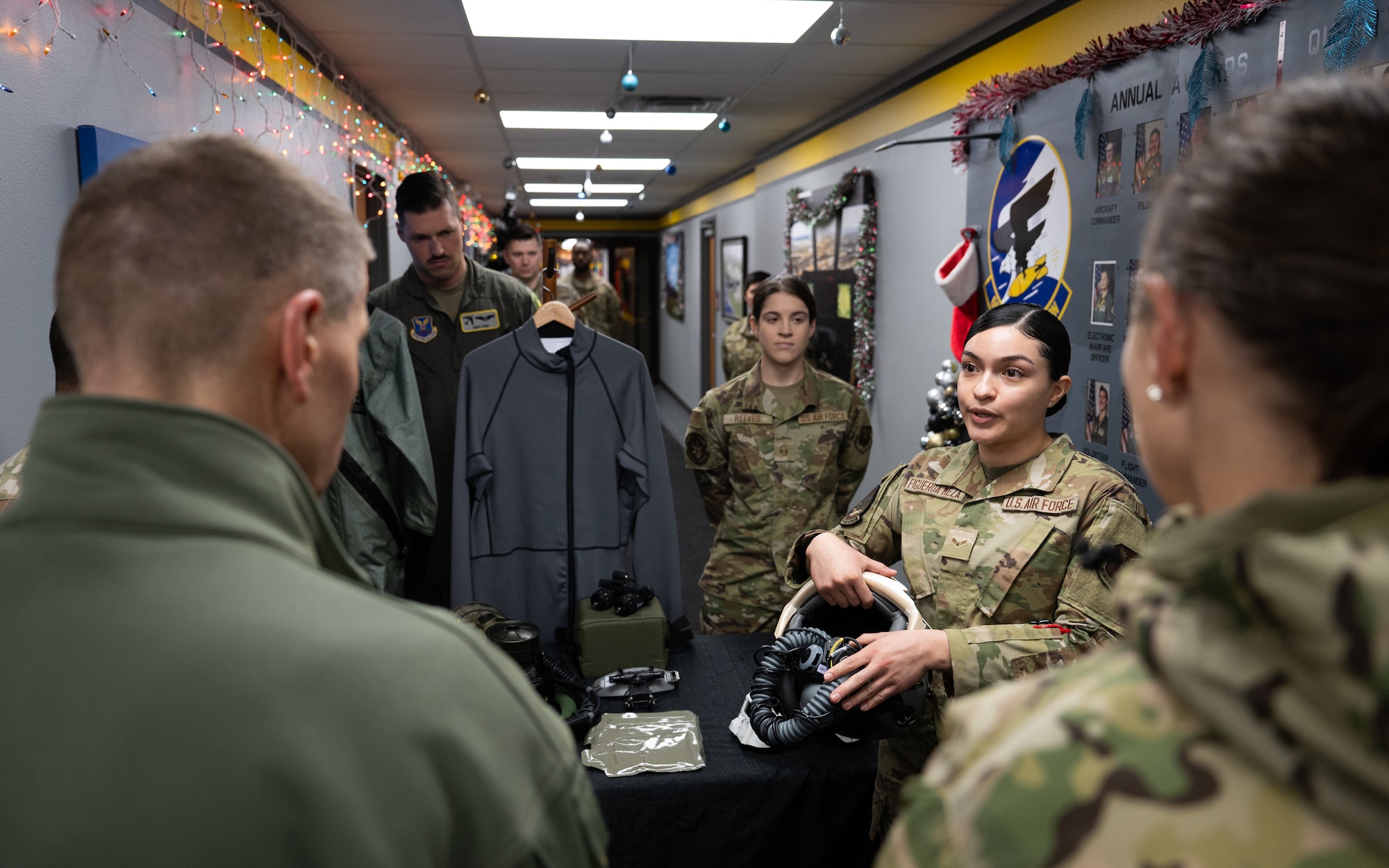 An Airman gives a presentation about pilots’ survival equipment to U.S. Navy Adm. Rich Correll (left).
