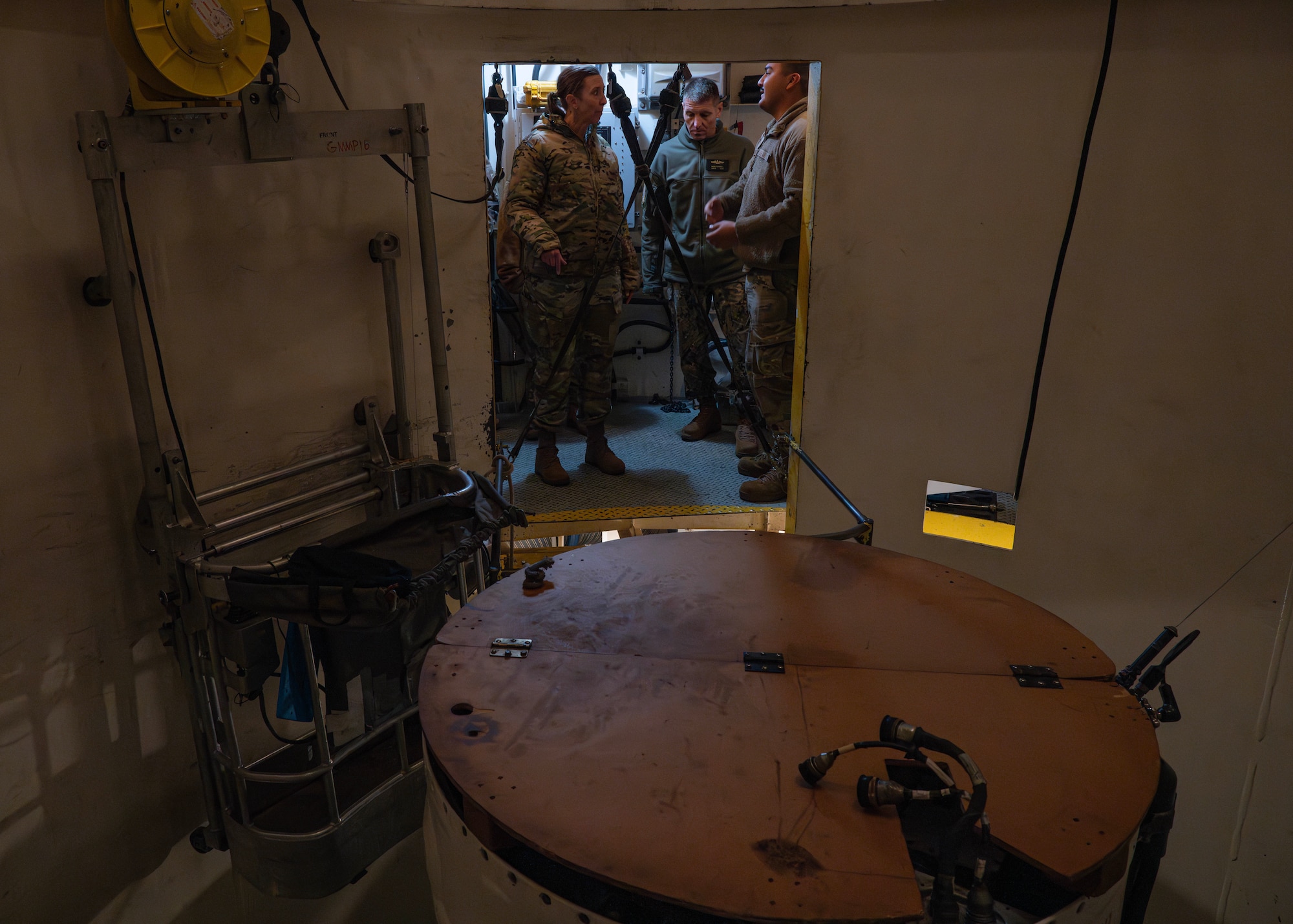 U.S. Navy Adm. Rich Correll receives a briefing from Airmen while inside of a training missile launch facility.