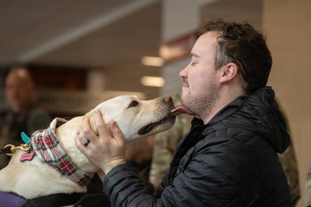 A federal worker pets Lyndon, a crisis response dog, during a Toys for Tots charity event at the Pentagon, Washington, D.C., Dec. 9, 2025. Since 1947, the Marine Corps Reserve has spearheaded the Toys for Tots program nationwide to collect toys for less fortunate children during the holiday season. Presently, the program distributes 7 to 18 million toys to children annually. (U.S. Marine Corps photo by Lance Cpl. Van Hoang)