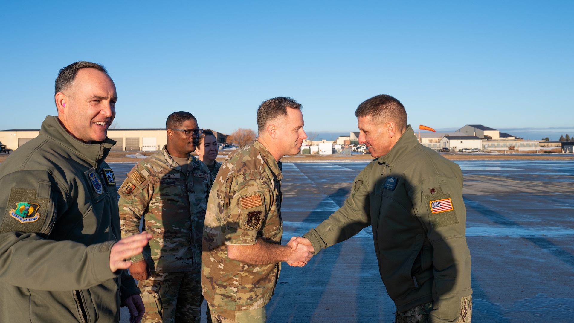 U.S. Navy Adm. Rich Correll (right) greets Team Minot leadership shortly after stepping off his aircraft.