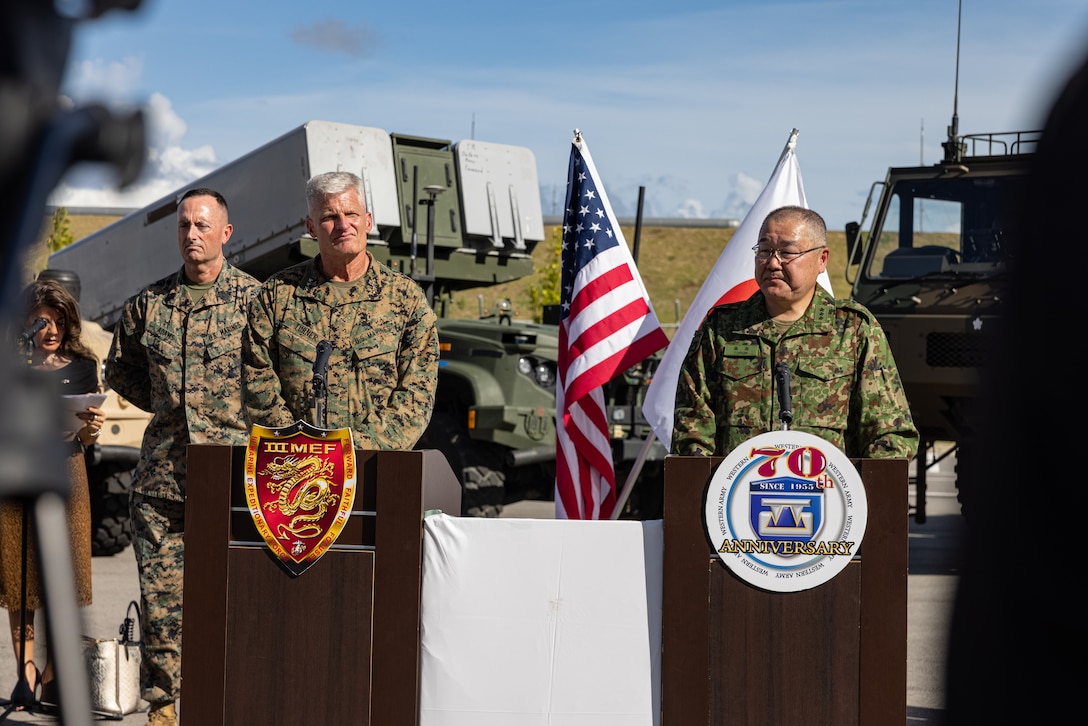 U.S. Marine Corps Sgt. Maj. Christopher Adams, far left, the sergeant major of III Marine Expeditionary Force, stands while Lt. Gen. Roger Turner, left, the commanding general of III Marine Expeditionary Force, and Japan Ground Self-Defense Force Lt. Gen. Seiji Toriumi, the commanding general of Western Army, speak about the capabilities of the Navy-Marine Expeditionary Ship Interdiction System at a press conference during Resolute Dragon 25 at JGSDF Camp Ishigaki, Okinawa, Japan, Sept. 17, 2025.