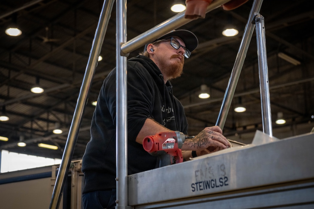 A man stands on a step ladder.