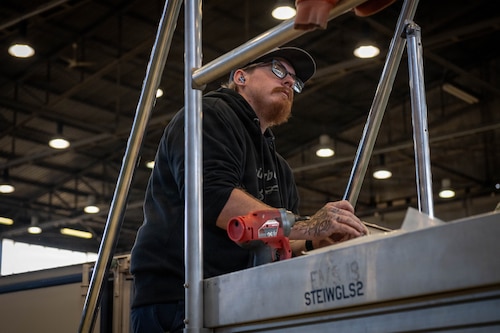 A man stands on a step ladder.