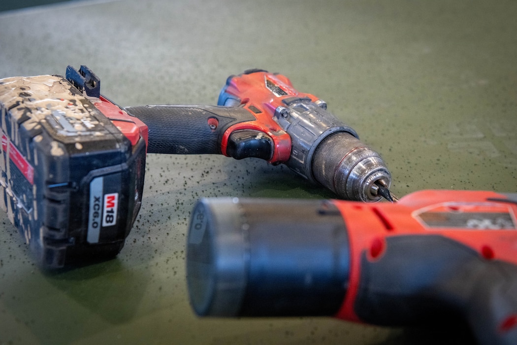 Two drills lay on a box.