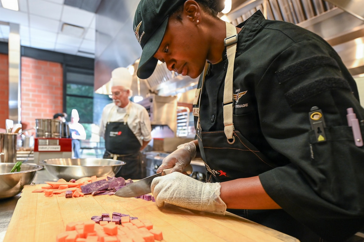 Airman Kedaeja Myrie-Mills, McConnell Air Force Base, Kan., cubes sweet potatoes during the second annual Salute Hospitality Epicurean Faceoff held at the San Antonio Culinary Institute of America in San Antonio, Texas, Dec. 3, 2025. Teams from 11 installations had 100 minutes to prepare, cook and present their dishes as well as clean their kitchen spaces. (U.S. Air Force photo by Craig Z. Rodarte)