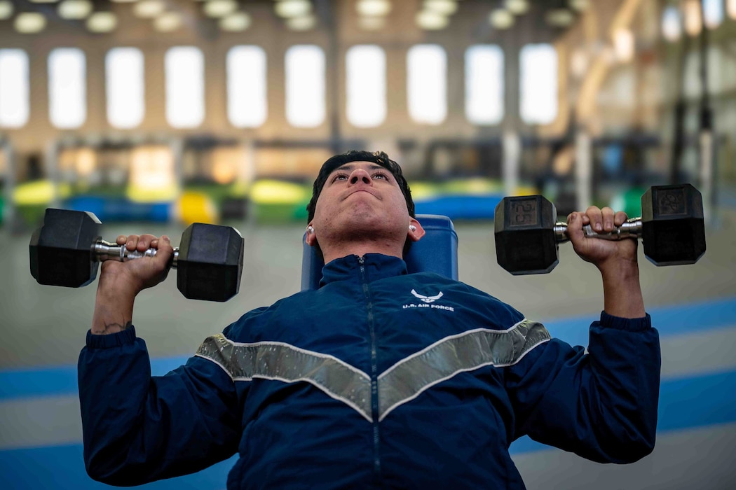Airmen lifting dumb bells