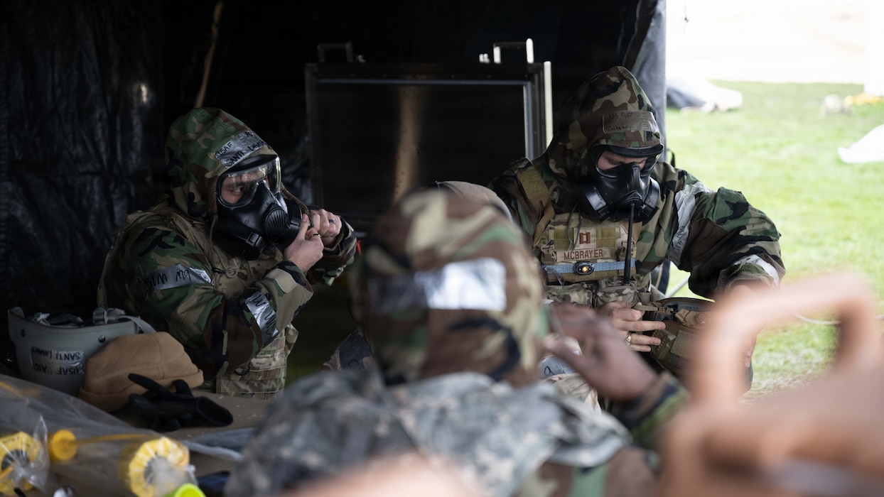 Airmen assigned to the 52nd Civil Engineer Squadron don mission-oriented protective posture gear during a beddown exercise at Spangdahlem Air Base, Germany, Dec. 5th, 2025. The event prepared Airmen to operate in chemical, biological, radiological, and nuclear threat environments while maintaining mission continuity. (U.S. Air Force photo by Senior Airman Darius Frazier)