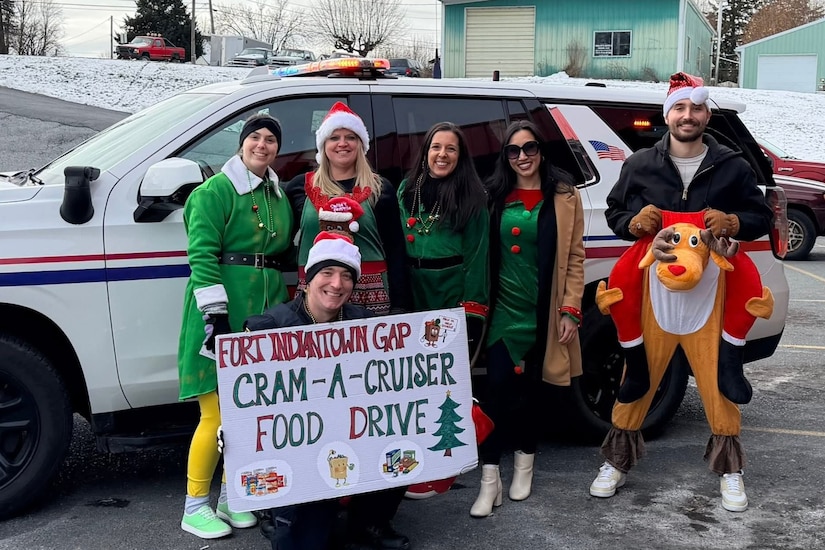 Members of the Fort Indiantown Gap police department and Fort Indiantown Gap Employees Association pose next to a police vehicle during the Cram-a-Cruiser campaign in Jonestown, Pennsylvania. More than 6,000 food items were collected that will be donated to area food banks to help those in need. (Courtesy photo)