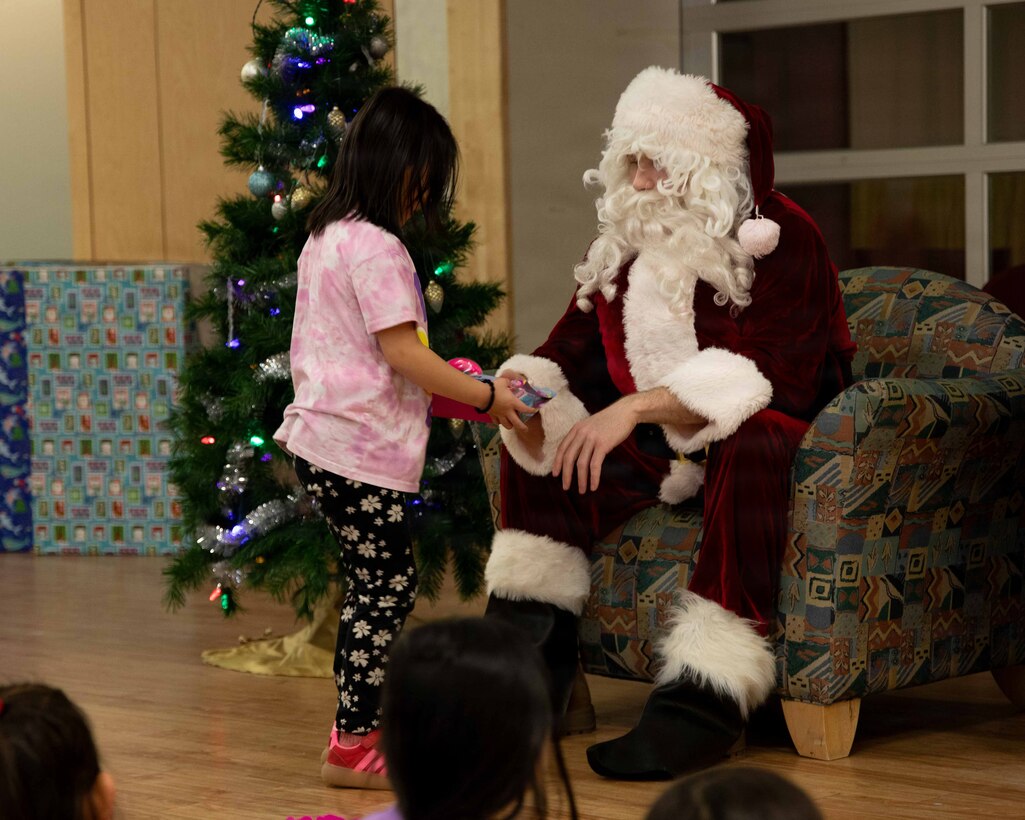 U.S. Marine Corps Capt. Daniel Kelly, dressed as Santa Claus, greets a child attending June Nelson Elementary School in Kotzebue, Alaska, Dec. 8, 2025. Kelly, a military police officer and inspector-instructor with the 4th Law Enforcement Battalion, Force Headquarters Group, delivered toys to the school with the assistance of Marines from Detachment Delta Company and U.S. airmen from various units during this year’s Toys for Tots operation. The Toys for Tots mission exemplifies the Marine Corps spirit in the Last Frontier, strengthening community ties while sharpening the Marines' readiness for Arctic operations.