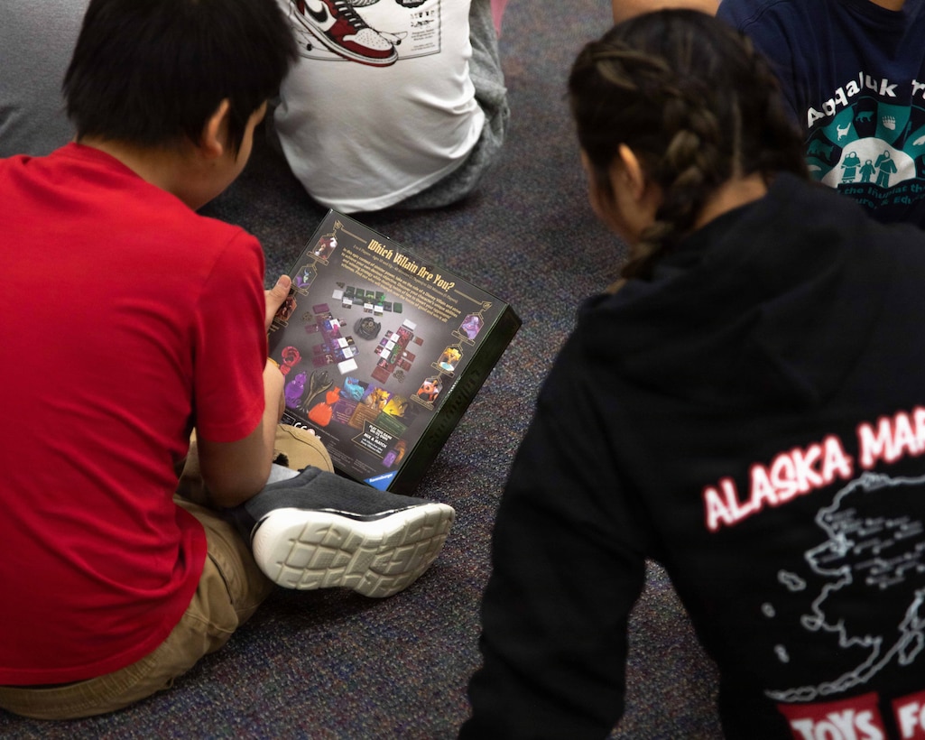 U.S. Airforce Senior Airman Cassandra Doucete, greets a child attending June Nelson Elementary School in Kotzebue, Alaska, Dec. 8, 2025. Doucete is an independent duty medical technician with the 962 Airborne Air Control Squadron, and a New Hampshire native. Marines with 4th Law Enforcement Battalion, Force Headquarters Group and Airmen stationed on Joint Base Elmendorf-Richardson, delivered toys to the school during this year’s Toys for Tots operation. The Toys for Tots mission exemplifies the Marine Corps spirit in the Last Frontier, strengthening community ties while sharpening the Marines' readiness for Arctic operations. (U.S. Marine Corps photo by Cpl. Orion Stpierre)
