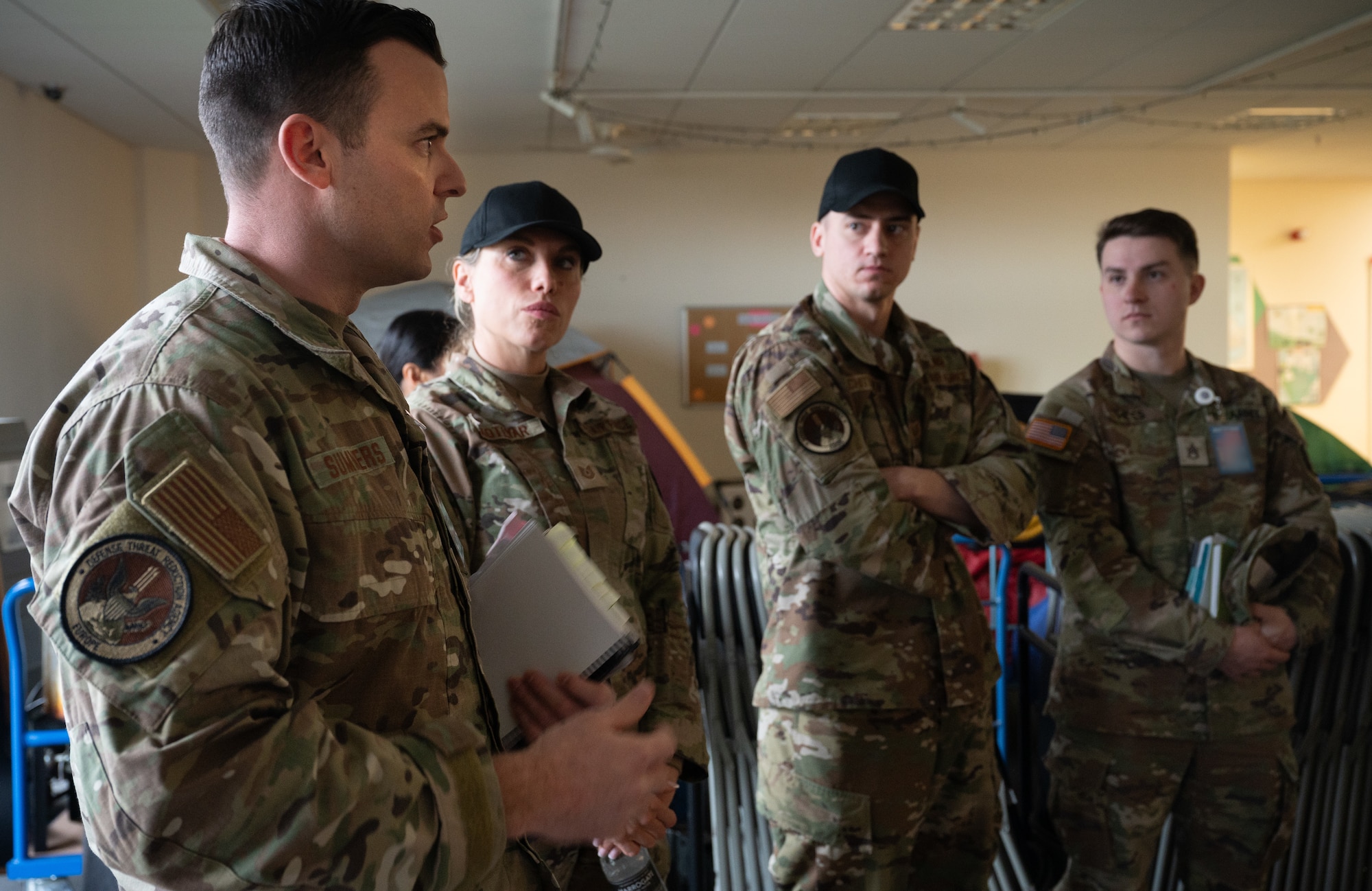 Military members listen to a brief.