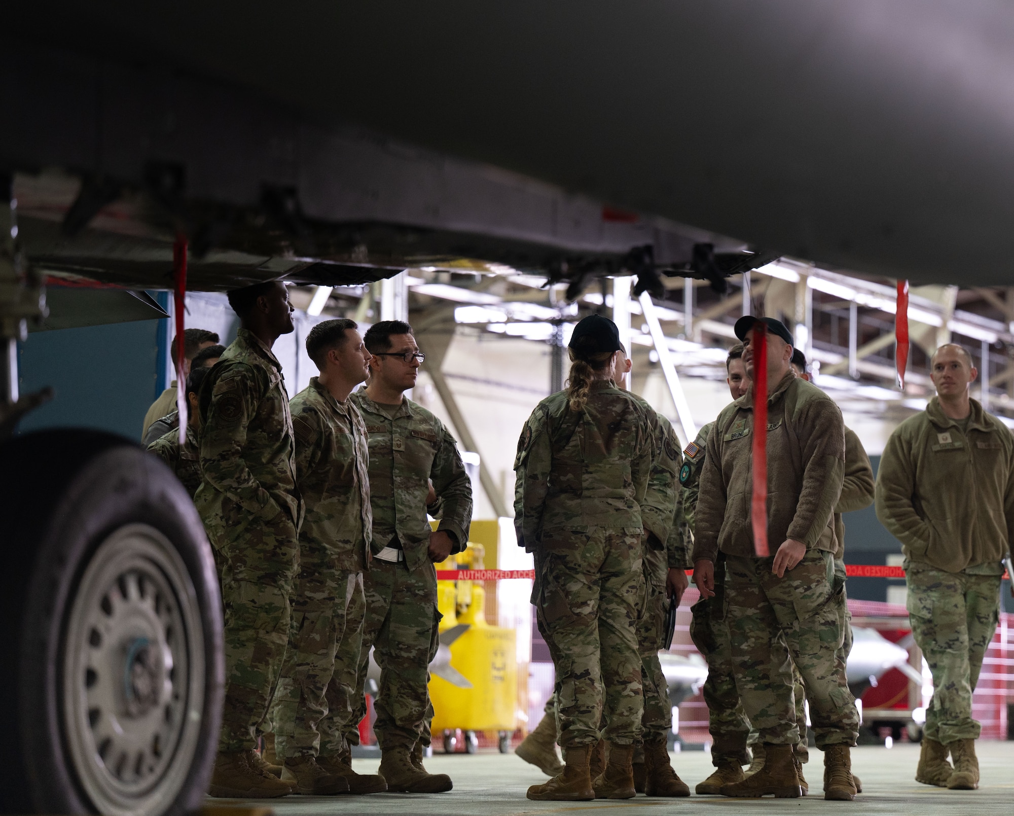 Military members gather in front of a plane.