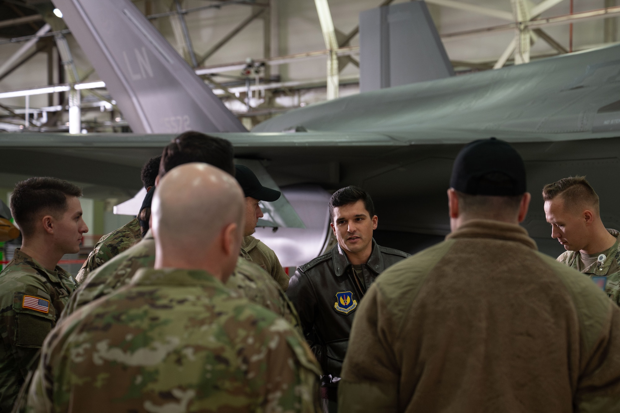 Military members gather around a pilot