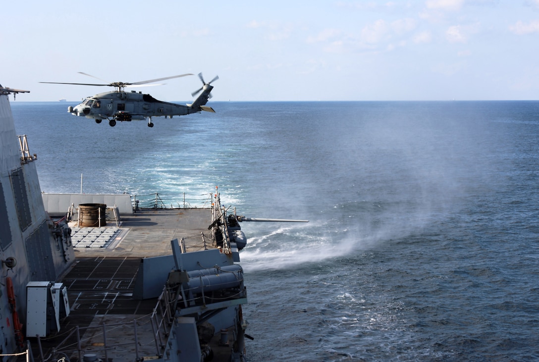 STRAIT OF HORMUZ (Dec. 15, 2025) An MH-60R Sea Hawk, assigned to Helicopter Maritime Strike Squadron (HSM) 79, departs from the flight deck of the Arleigh Burke-class guided-missile destroyer USS Roosevelt (DDG 80) during a Strait of Hormuz transit. Roosevelt is deployed to the U.S. 5th Fleet area of operations to support maritime security and stability in the U.S. Central Command area of responsibility. (U.S. Navy photo by Mass Communication Specialist 1st Class Indra Beaufort)