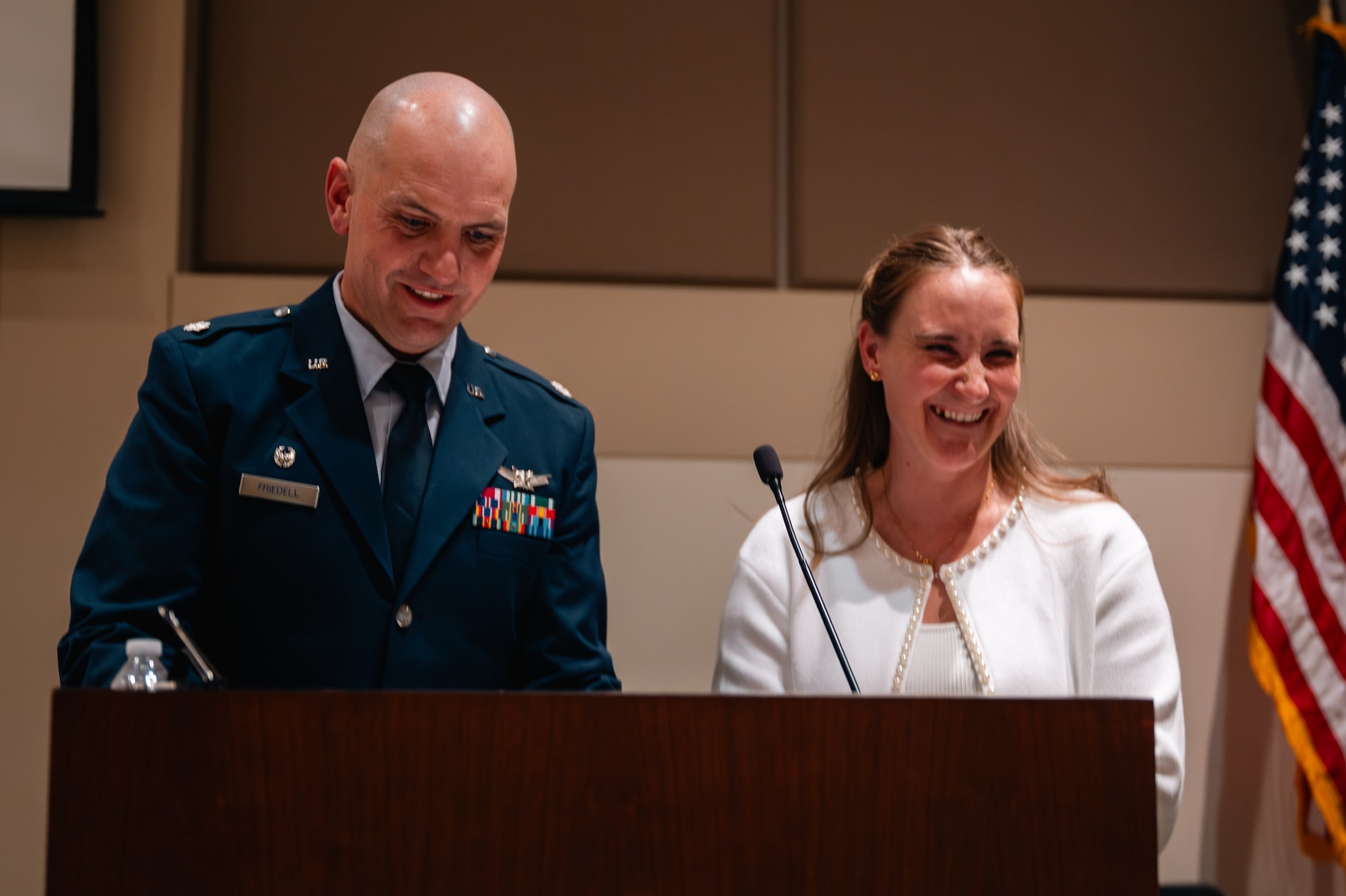 man and woman stand at a podium