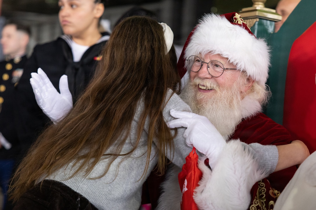 Santa Claus hugs a child at a Toys for Tots charity event on Marine Corps Base Quantico, Virginia, Dec. 8, 2025. Since 1947, the Marine Corps Reserve has spearheaded the Toys for Tots program nationwide to collect toys for less fortunate children during the holiday season. Presently, the program distributes 7 to 18 million toys to children annually. (U.S. Marine Corps photo by Lance Cpl. Van Hoang)
