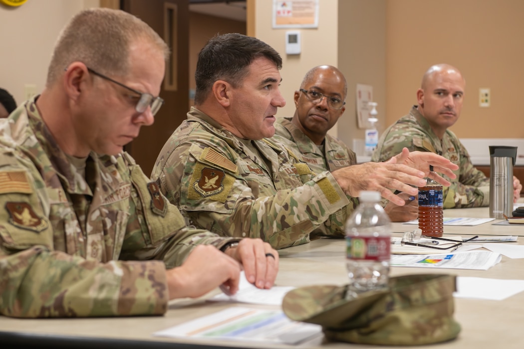 Men in military uniforms gather around a table.
