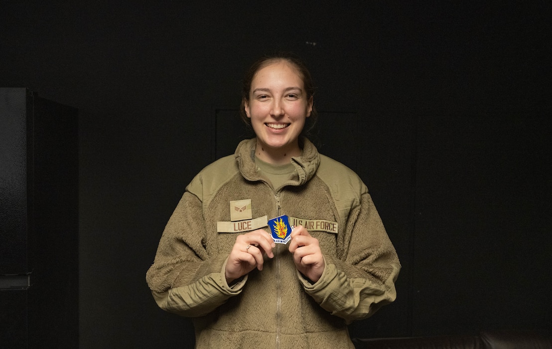 U.S. Air Force Senior Airman Sarah Luce, 97th Operations Support Squadron air traffic control trainer displays her coin at Altus Air Force Base, Oklahoma, Dec. 15, 2025. Luce was coined by U.S. Air Force Col. Richard Kind, 97th Air Mobility Wing commander, since she was named the 2025 fiscal year Air Education and Training Command Airfield Operations Trainer of the Year. (U.S. Air Force photo by Airman 1st Class Emma Wright)